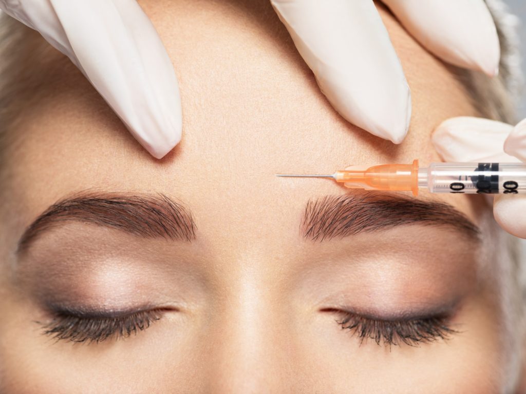 Woman getting cosmetic injection of botox near eyes in salon | Aesthetic Artistry in Burke, VA